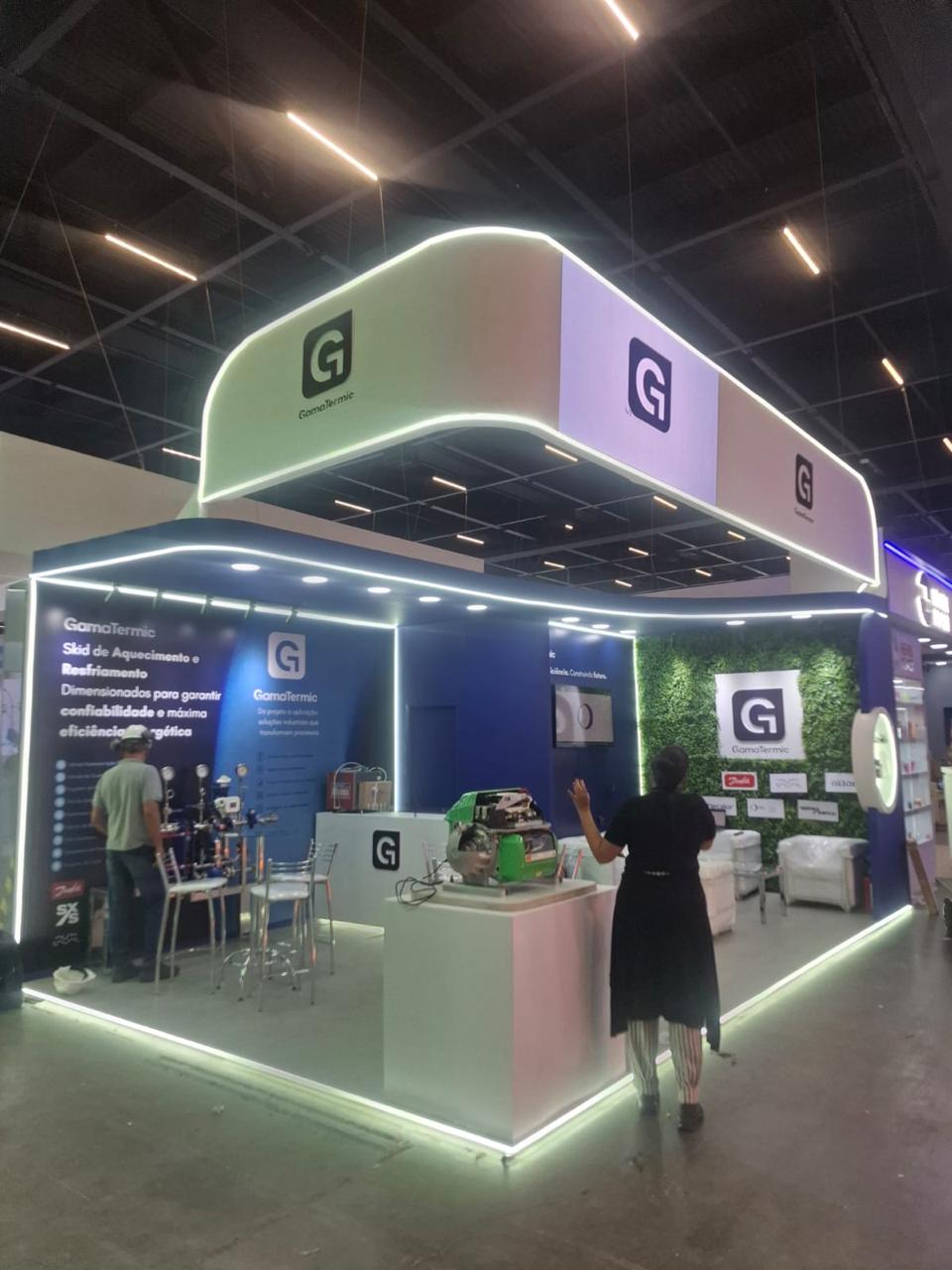 Vista ampla do stand GamaTermic, com estrutura curva iluminada e identidade da marca